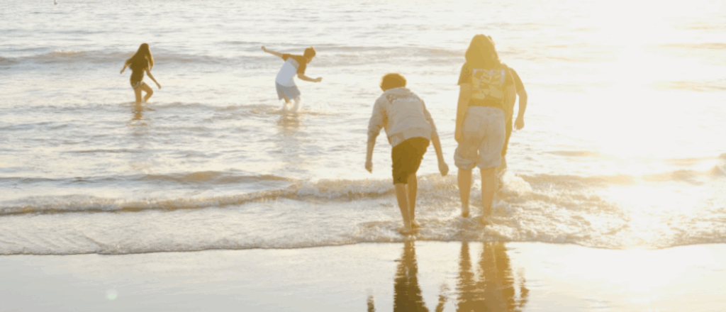 Family at the beach, playing in the sea